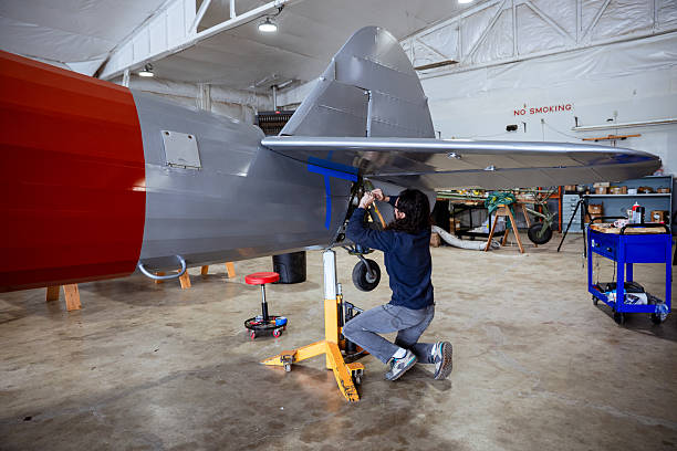 A certified airplane mechanic working on a vintage aircraft fuselage for rebuilding and repair. Shot in Oregon USA.