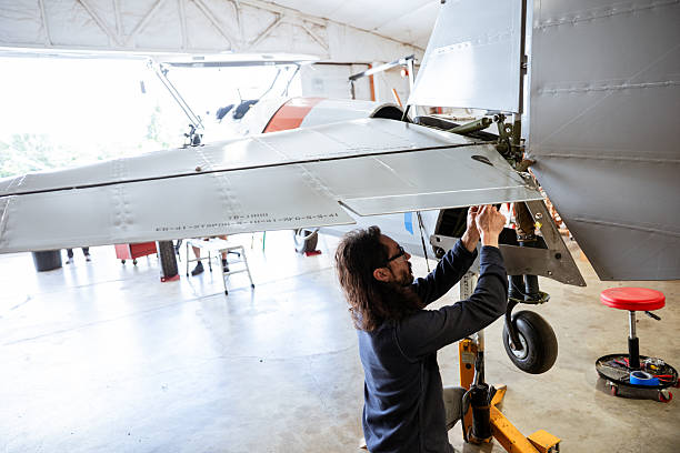 A certified airplane mechanic working on a vintage aircraft fuselage for rebuilding and repair. Shot in Oregon USA.