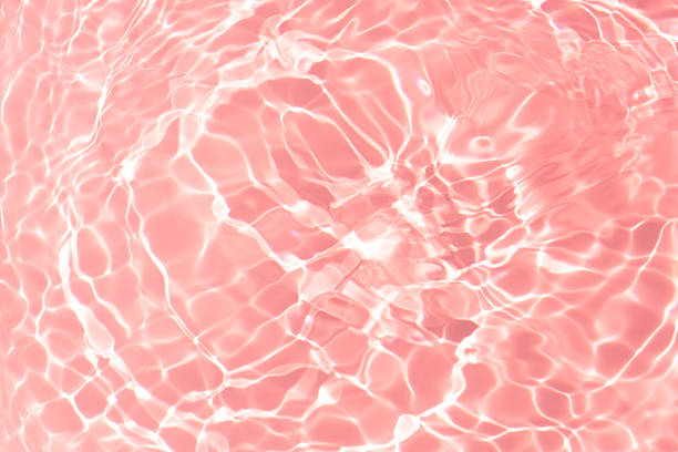 istock Pink water bubbles on the surface ripples. Defocus blurred transparent pink colored clear calm water surface texture with splash and bubbles. Water waves with shining pattern texture background 2227297639