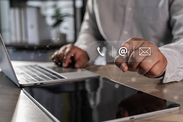 istock Contact us Business professional using digital icons for communication tablet with laptop background, showing modern technology and connectivity 2227301064