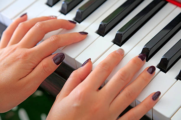 Women's fingers playing the piano