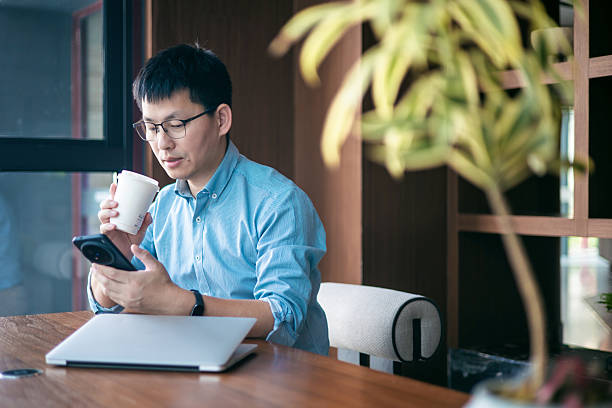 istock Businessman working on a laptop computer and texting or using social media on a mobile phone in the office 2227311104