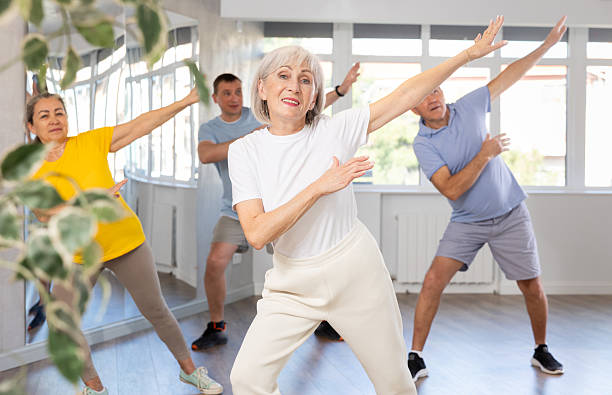 istock Cheerful elderly woman learning dynamic dances at group choreography lesson 2227317009