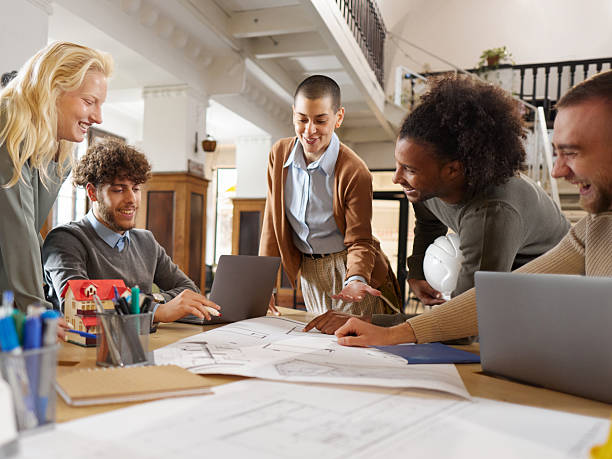 istock Team of happy architects working on blueprints in the office. 2227317609