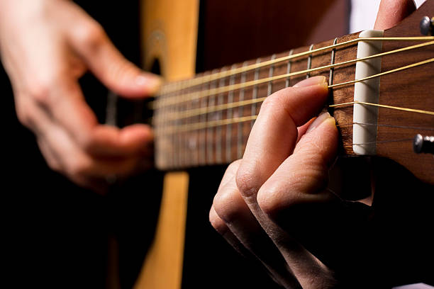 istock guitar playing, black background. lifestyle, close-up. 2227317855