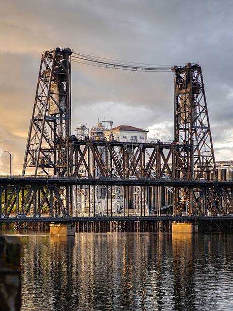 istock Steel bridge with industrial backdrop at sunset. 2227318573