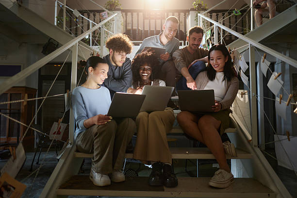 istock Happy creative colleagues using wireless technology on staircase in a hallway. 2227318600