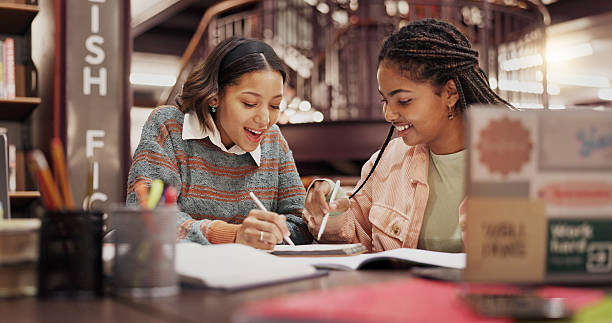 istock Students, women and friends with notebook at library for group project, research or education at university. People, girl and review with problem solving, notes or learning for scholarship at college 2227322934