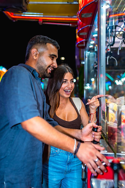 istock Young couple playing claw crane game at amusement park 2227323659