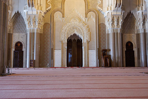 Mature woman in front of one of the doors of the Hassan II Mosque in Casablanca, Morocco. The mosque is one of the largest in the world.