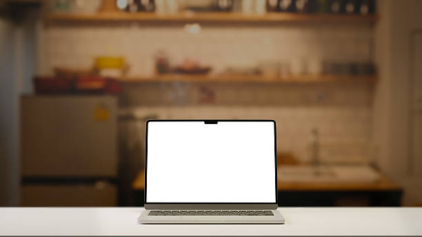 istock Laptop with blank screen on on a countertop in a blurred kitchen interior background. 2227327105