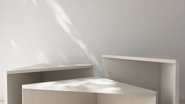 istock Three minimal, modern triangle geometric shape pedestal podium table in gray cement color in foliage dappled sunlight on white wall for luxury, elegant cosmetic, skincare, body care, beauty product display background 3D 2227327636