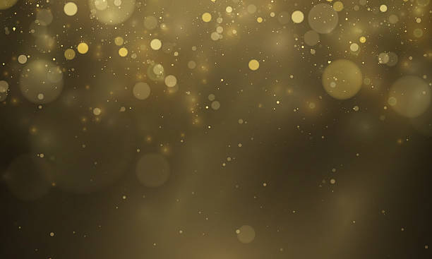 istock Shimmering gold particles and twinkling stars form a light cloud on a transparent dark background. 2227328495