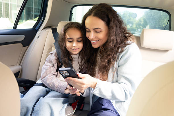 istock Mom and daughter spending time together and watching something while sitting in a car 2227332412
