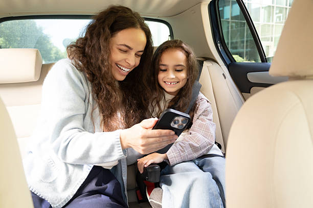 istock Mom and daughter spending time together and watching something while sitting in a car 2227332419