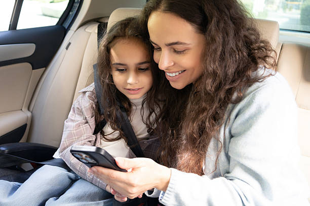 istock Mom and daughter spending time together and watching something while sitting in a car 2227332429