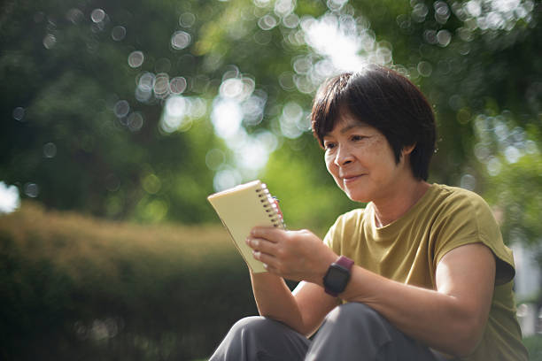 istock Mature woman taking notes while relaxing in nature. 2227333802