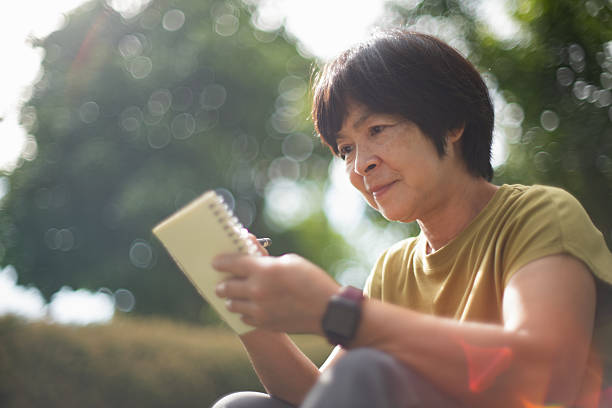 istock Mature woman taking notes while relaxing in nature. 2227333805