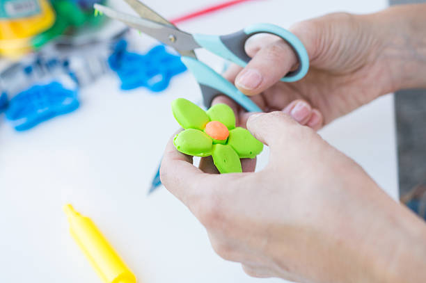 istock Teacher molding a plasticine flower at school 2227334537