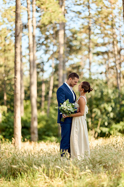 istock Bride and Groom Embracing in a Sunlit Forest Setting 2227337016