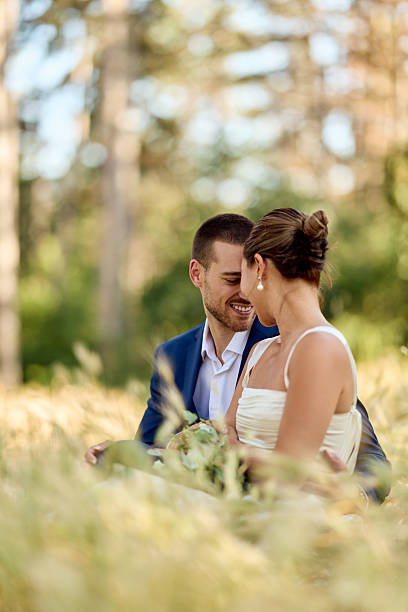 istock Romantic Newlyweds Sitting in a Sunny Meadow Sharing an Intimate Moment 2227337024
