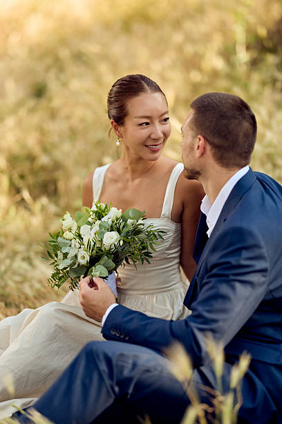 istock Bride and Groom Enjoying a Romantic Moment in a Sunny Field 2227337033