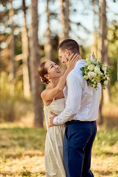 istock Bride and Groom Embracing Joyfully in a Scenic Outdoor Setting 2227337045