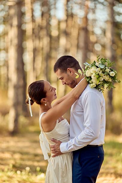istock Romantic Wedding Couple Embracing Outdoors in Nature with Bouquet 2227337058