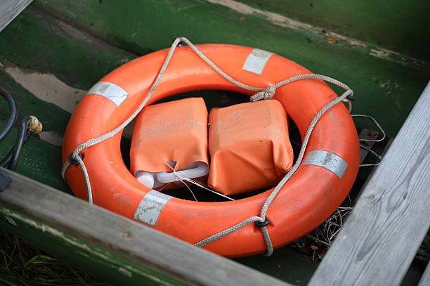 istock A bright orange life preserver that has a rope securely wrapped around it 2227337392