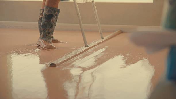istock Worker smoothing self-leveling anhydrite gypsum screed 2227337417
