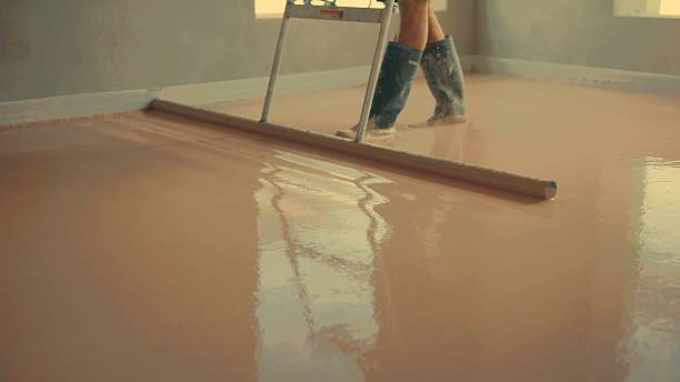 istock Construction worker leveling self-leveling anhydrite gypsum screed with a smoothing tool 2227337418