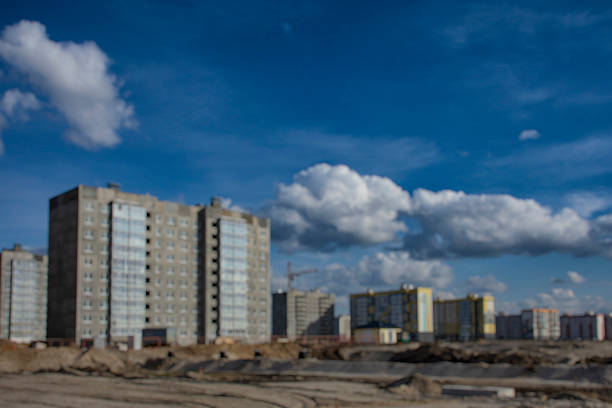 Blurred image captures the essence of a construction site, featuring multiple buildings under a vast sky