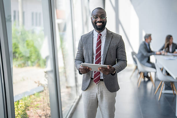istock Smiling businessman holding digital tablet in modern office 2227339143