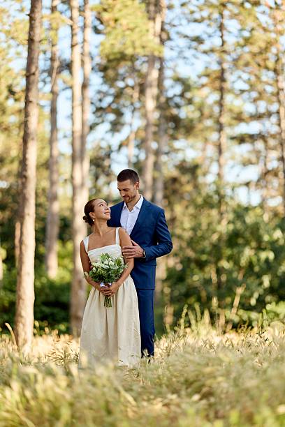 istock Romantic Couple Posing in a Sunlit Forest During Their Wedding Ceremony 2227339867