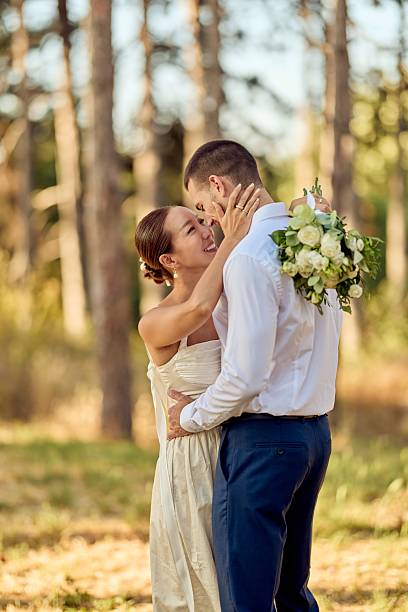 istock Romantic Wedding Couple Embracing Outdoors in a Sunlit Forest Setting 2227339879