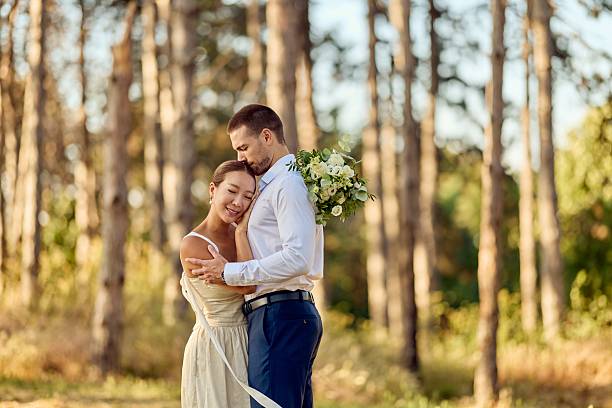istock Bride and Groom Embracing in a Lush Forest on Their Wedding Day 2227339885