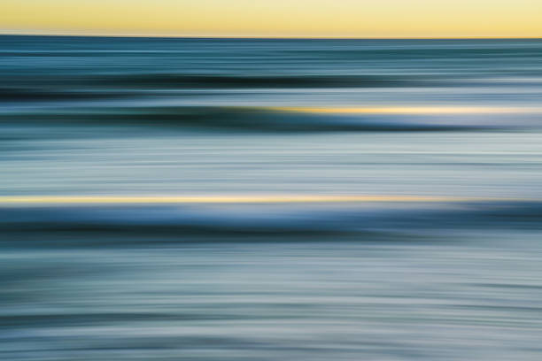istock Soft, flowing ocean waves captured in a blur during sunset. 2227340891