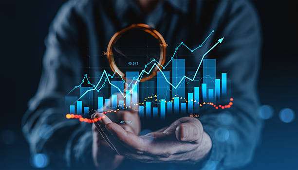 istock Businessman holding financial graph with magnifying glass, symbolizing data analytics, investment growth and stock market forecast concept. 2227341996
