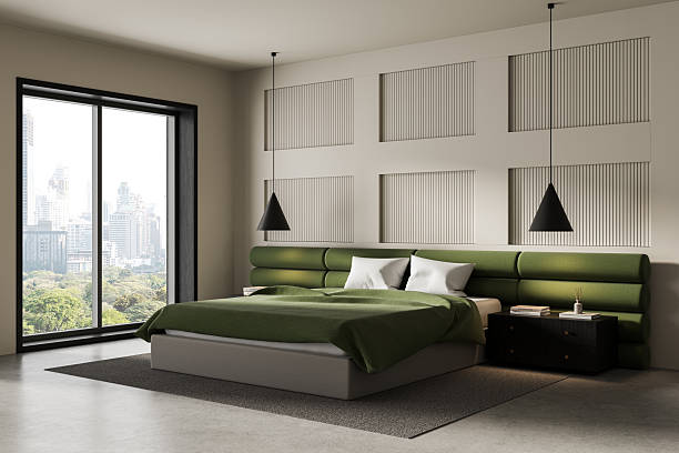 Modern bedroom interior with green upholstered headboard and large window overlooking cityscape, featuring pendant lighting and neutral tones. 3D Rendering