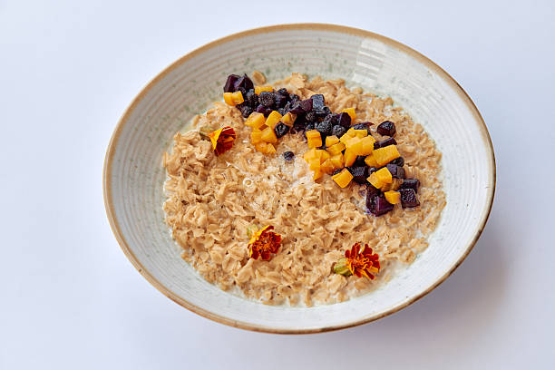 Delicious Oatmeal Bowl Topped with Dried Fruits and Flowers for a Nutritious Breakfast Experience