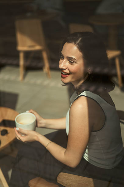 istock Young woman laughing and drinking coffee in cafe 2227347038
