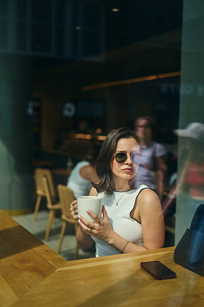 istock Young woman enjoying a coffee break in a modern cafe 2227347415