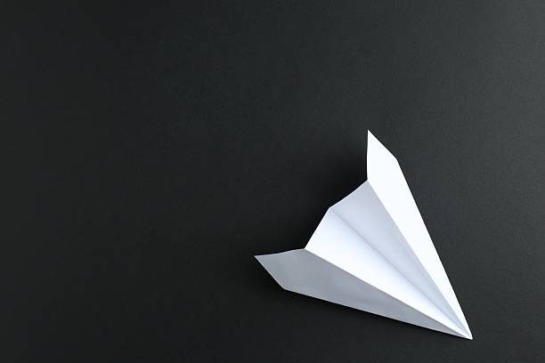 istock One handmade paper plane on black background, top view. Space for text 2227347511