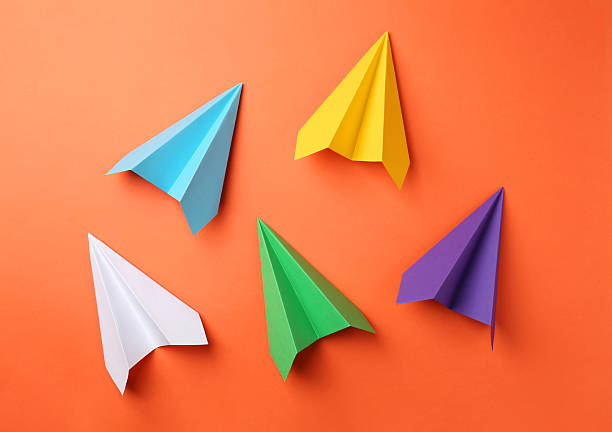 istock Handmade color paper planes on orange background, flat lay 2227347564