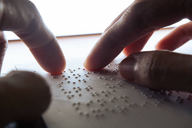 istock Visually impaired individuals utilize their fingertips to perceive Braille on paper, enabling them to read 2227348751