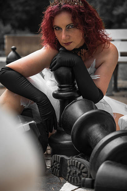 istock Ethereal chess queen poses amidst oversized pieces in a serene park setting capturing a whimsical moment of creativity and elegance 2227349312