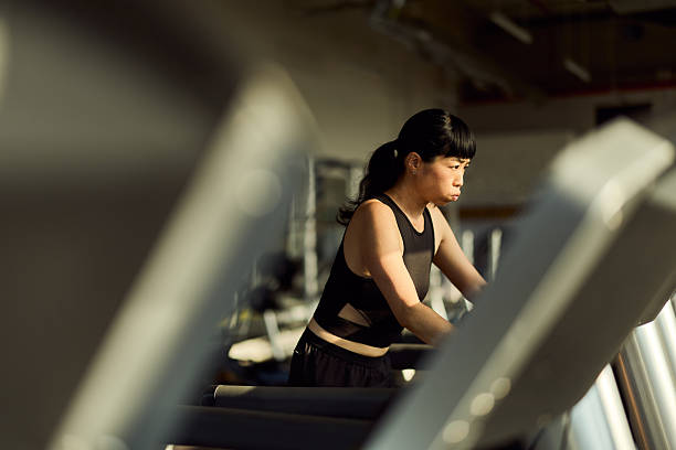 istock Focused Woman Exercising on a Treadmill in a Gym Setting 2227350005