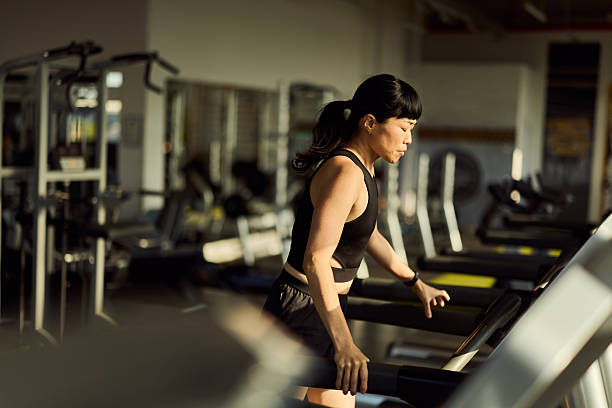 istock Woman Exercising on Treadmill in Well-Lit Modern Gym Setting 2227350010