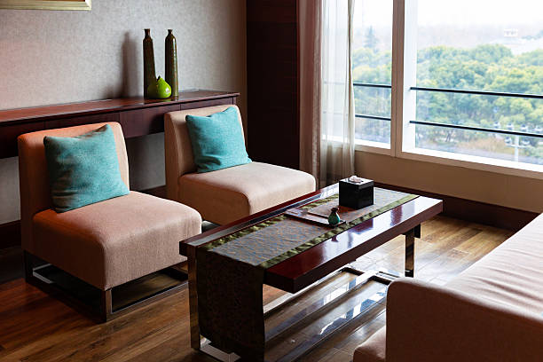 istock Fabric sofa placed by the window with flower arrangement on the side 2227350542