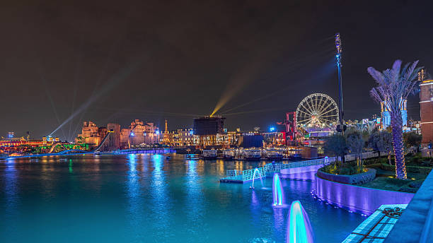 Panorama showing Riyadh Boulevard World entertainment park with illuminated attractions famous landmarks. Largest artificial lake on the world with floating boats night timelapse. Riyadh. Saudi Arabia
